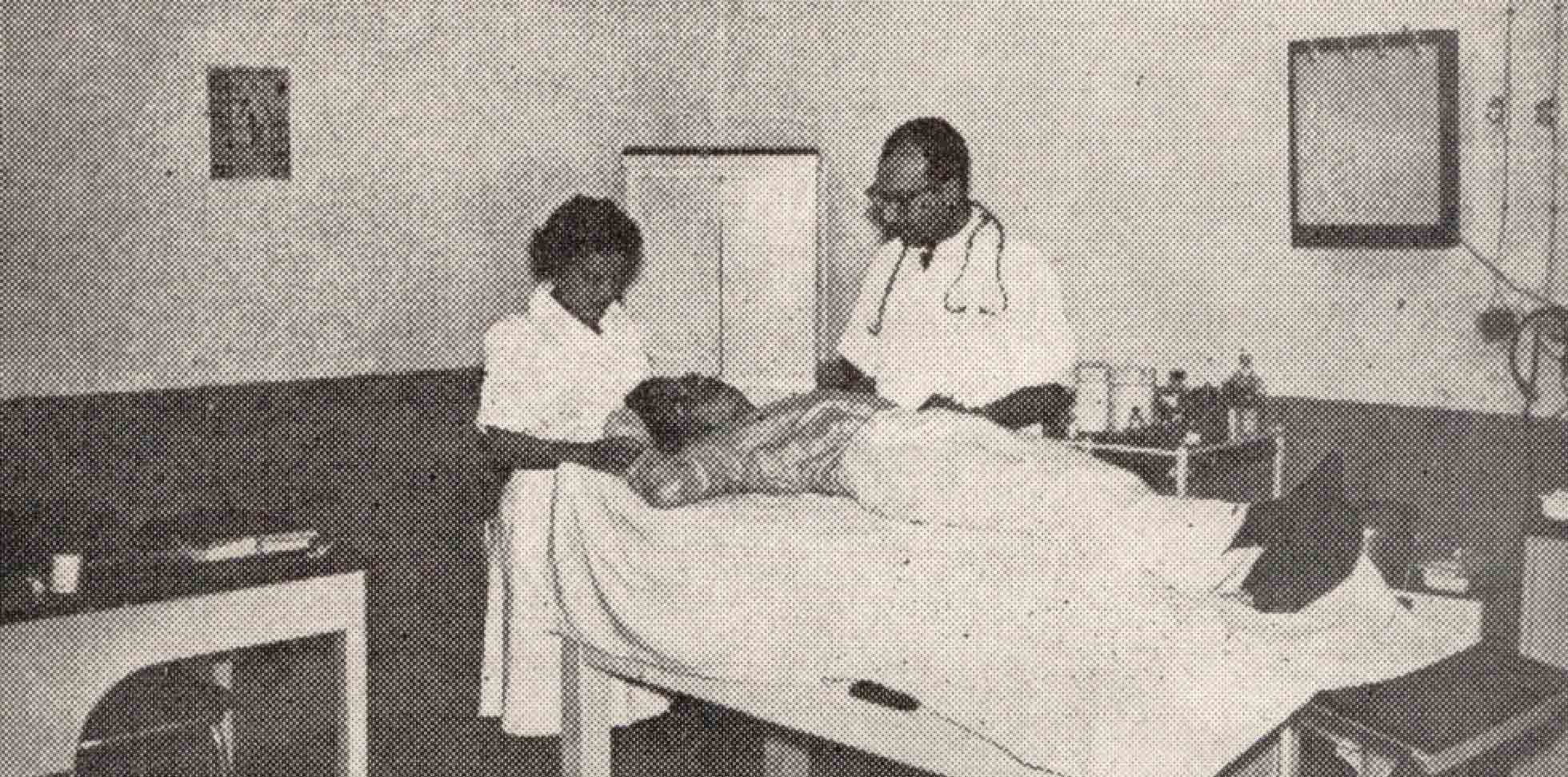 Médico y enfermera atendiendo a un paciente en una sala de consulta, en los primeros años del IGSS